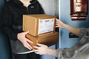 postal courier handing packages over to customer