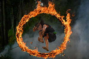 A Thai fire dace performer jumping through a hoop of fire